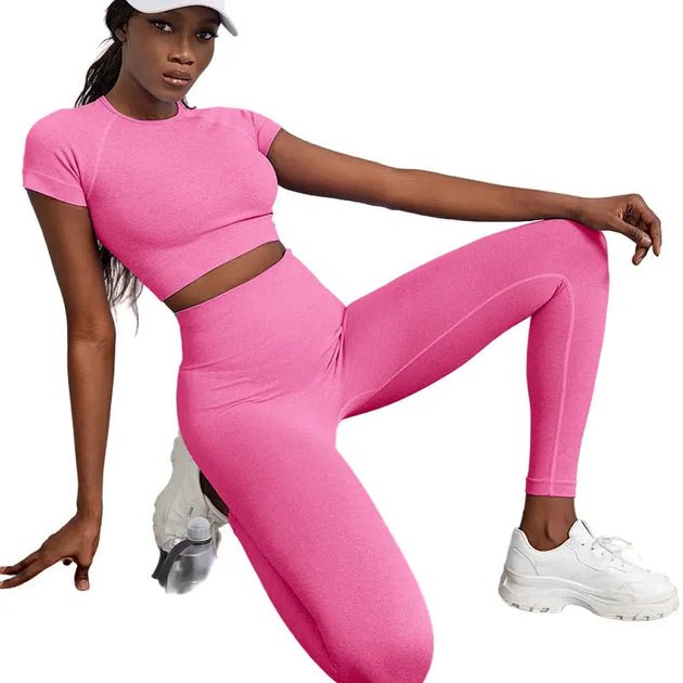 Woman wearing pink 2-piece quick-dry yoga workout outfit with high-waist leggings and crop top