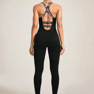 Back view of a black seamless camisole jumpsuit with crisscross elastic straps and cutout detail, fitted and stretchy for a snug silhouette