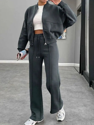 Woman wearing black baseball collar zip up outerwear and drawstring pants set with white sneakers