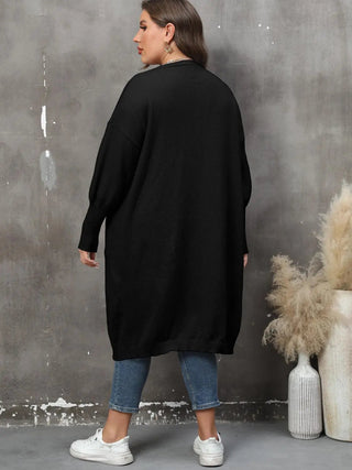 Plus size long sleeve black ribbed cardigan with pockets and open front worn with jeans and white sneakers