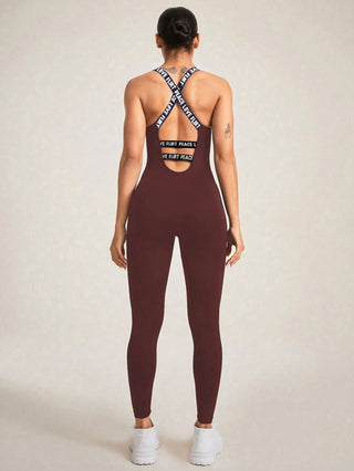 Back view of woman wearing seamless camisole jumpsuit in dark brown with crossed straps and athletic fit