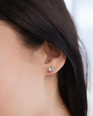 Close-up of blue topaz stud earring in 18k gold vermeil on woman’s ear