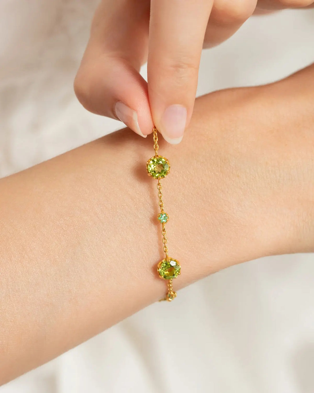Handcrafted emerald and peridot bracelet in 18k gold vermeil on wrist, part of Emerald & Peridot Jewellery Set