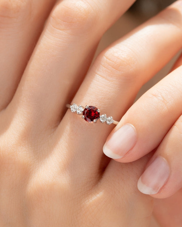 Close-up of a handcrafted garnet ring with round cut red gemstone and simulated diamonds in sterling silver, part of the Garnet Everyday Jewellery set