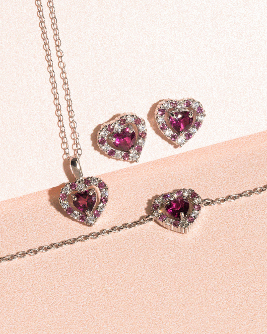 Red Heart Rhodolite Garnet stud earrings and pendant set in sterling silver with heart-shaped raspberry red gemstones and simulated diamonds