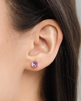 Close-up of a woman's ear wearing a lavender amethyst round-cut stud earring in 18k gold vermeil setting