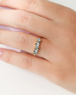 Blue Sapphire and Blue Topaz pear cut half eternity band in 18k gold vermeil on hand wearing ring