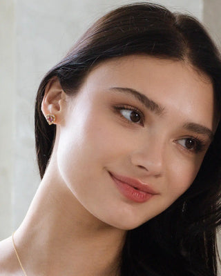 Woman wearing purple heart lavender amethyst stud earrings in 18k gold vermeil