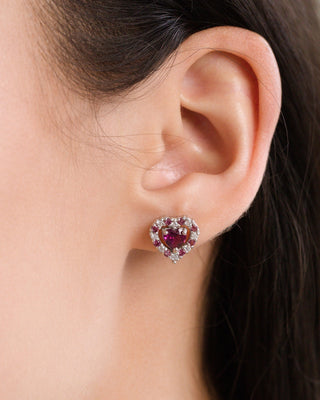 Close-up of red heart rhodolite garnet stud earring in sterling silver on ear