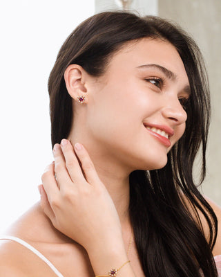 Woman wearing red heart rhodolite garnet stud earrings in 18k gold vermeil handcrafted double heart design