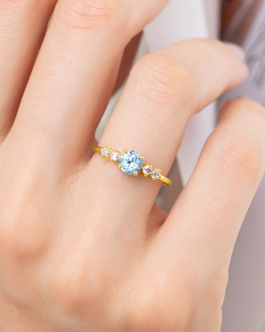 Handcrafted 18k gold vermeil ring with round cut sky blue topaz and simulated diamonds, part of blue topaz jewelry set.