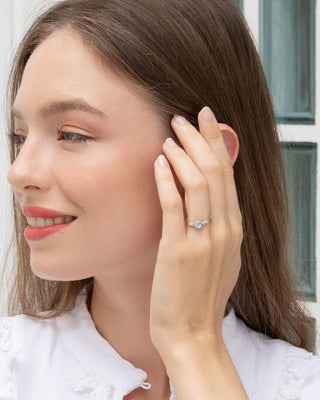 Close-up of a woman wearing a handcrafted blue topaz everyday jewellery set with sterling silver ring and earrings