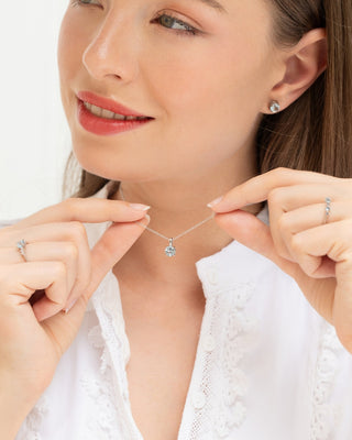 Woman wearing blue topaz everyday jewellery set with necklace, ring, and stud earrings in sterling silver