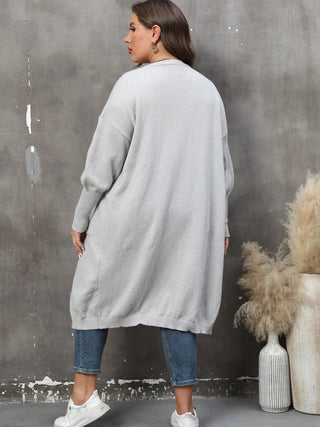 Plus size long sleeve gray ribbed cardigan with pockets and open front worn with jeans and white sneakers