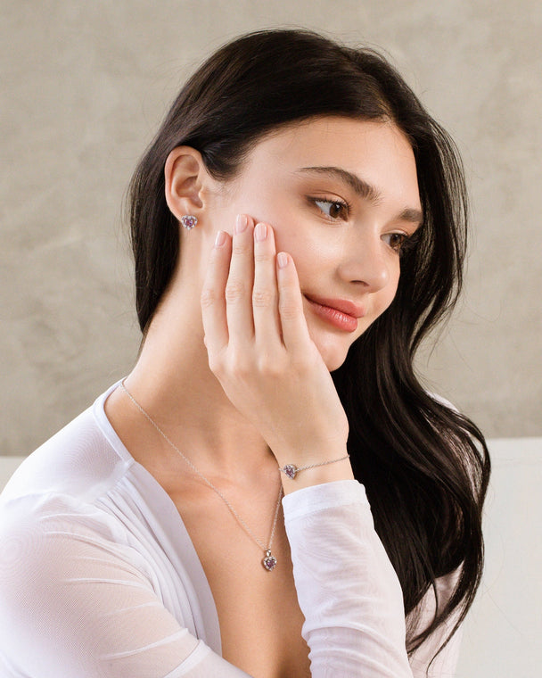 Woman wearing a purple heart lavender amethyst sterling silver necklace, bracelet, and stud earrings set