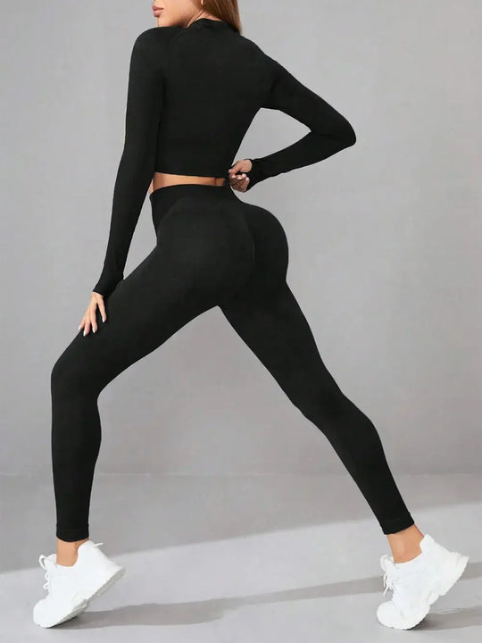 Woman wearing black mock neck long sleeve top and leggings active set in a yoga stretch pose