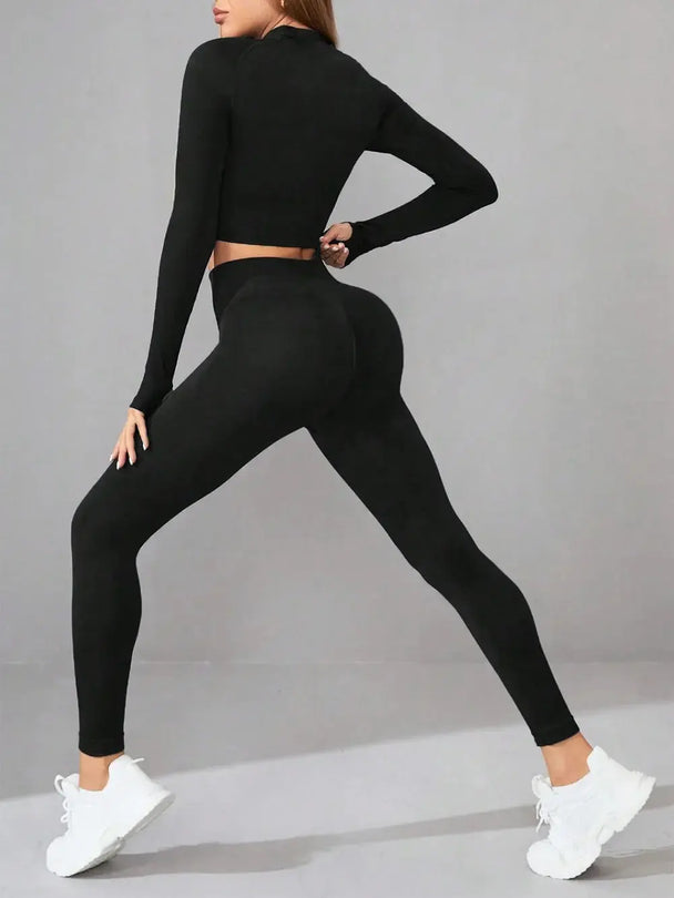 Woman wearing black mock neck long sleeve top and leggings active set in a yoga stretch pose
