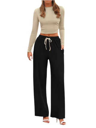 Woman wearing beige round neck long sleeve top and black drawstring pants set