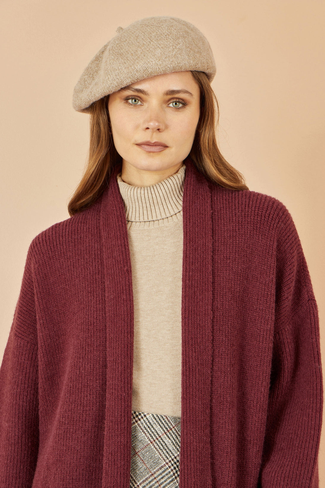 Yumi oatmeal soft knitted beret worn by woman with maroon cardigan and beige turtleneck