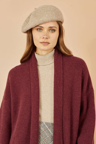 Yumi oatmeal soft knitted beret worn by woman with maroon cardigan and beige turtleneck