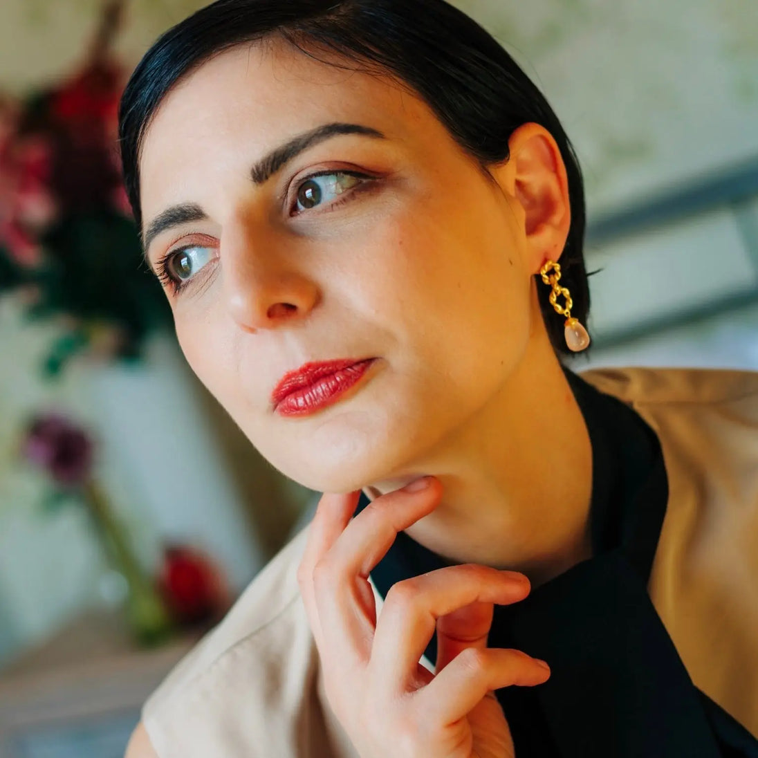 Woman wearing Moirai Double Twisted Loops Earrings with rose quartz and 22K gold on recycled brass