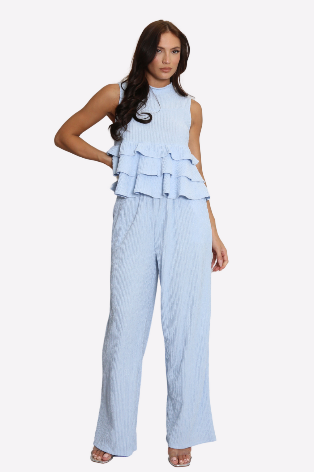Woman wearing light blue high neck frill blouse with matching flared pants co-ord set