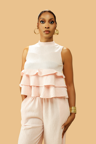 Woman wearing a pink high neck frill blouse with matching flared pants co-ord set