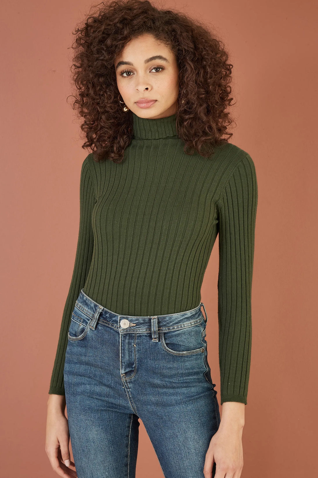 Yumi Green Ribbed Knit roll neck jumper worn with blue jeans on model
