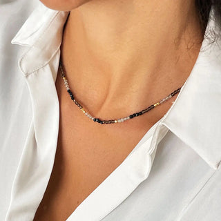 Milos Mixed Gemstone Beaded Necklace with black onyx, smoky quartz, labradorite, and 22k gold accents on adjustable chain worn with white shirt
