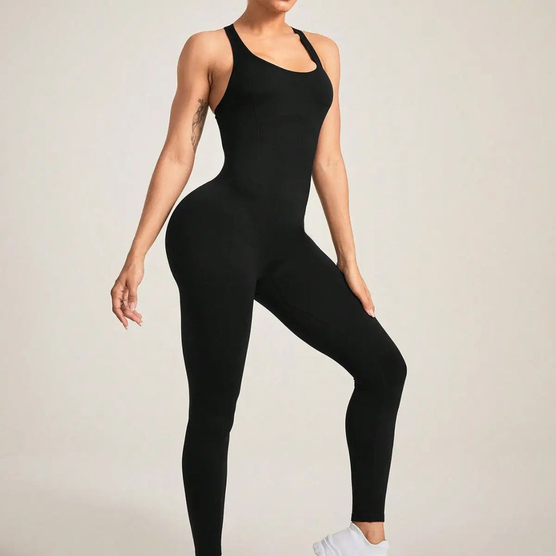 Black seamless camisole jumpsuit with high elastic fit and slim straps, worn by a woman