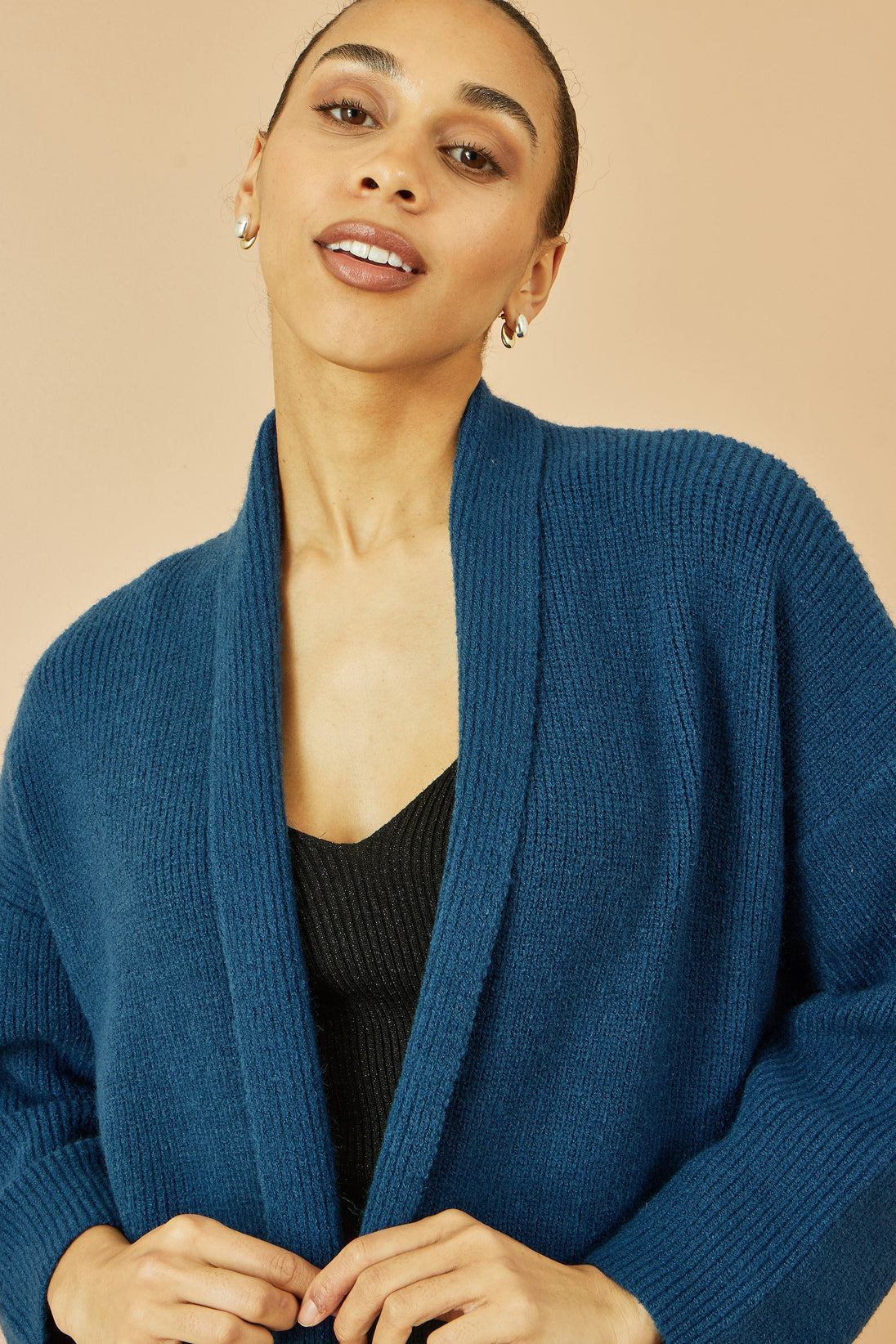 Woman wearing Yumi Teal Knitted Maxi Cardigan with pockets and vertical ribbed detail