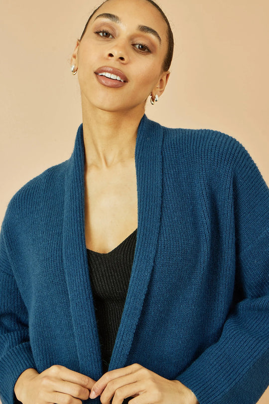 Woman wearing Yumi Teal Knitted Maxi Cardigan with pockets and vertical ribbed detail