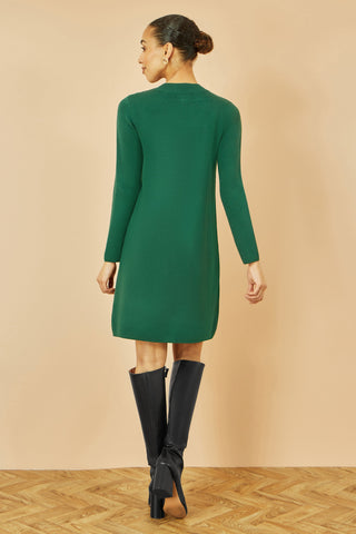 Yumi Green Knitted Tunic dress with gold hardware buttons on shoulder and pockets, long sleeve relaxed fit with black boots