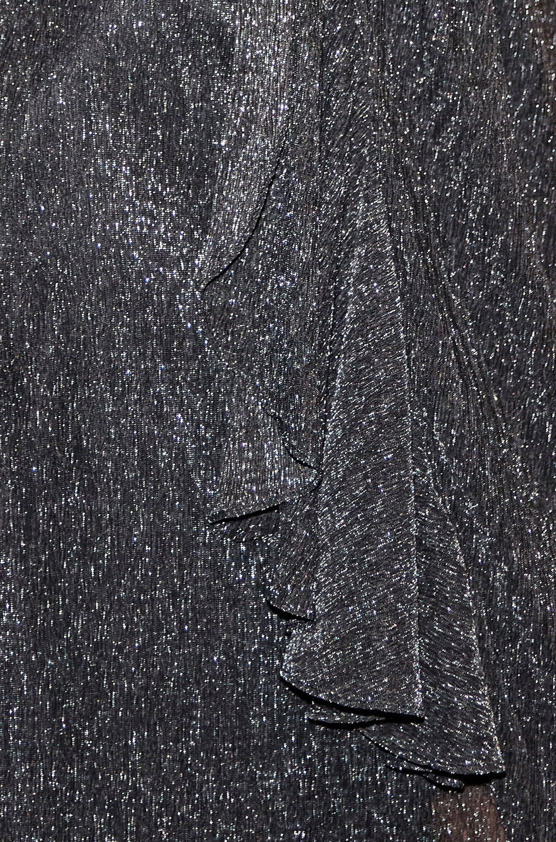 Close-up of Yumi black metallic pleated fabric with frill detail from wrap midi dress