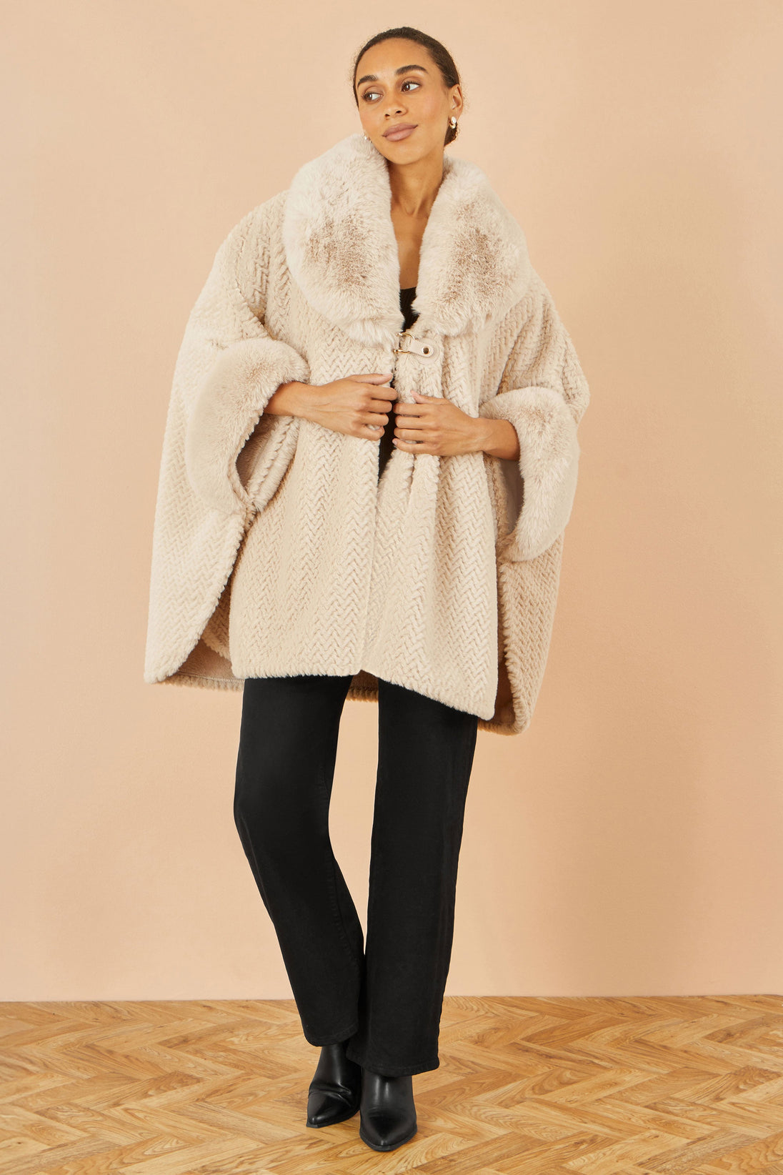 Yumi Beige Textured Fur lined cape with oversized buckle fastening collar worn by model
