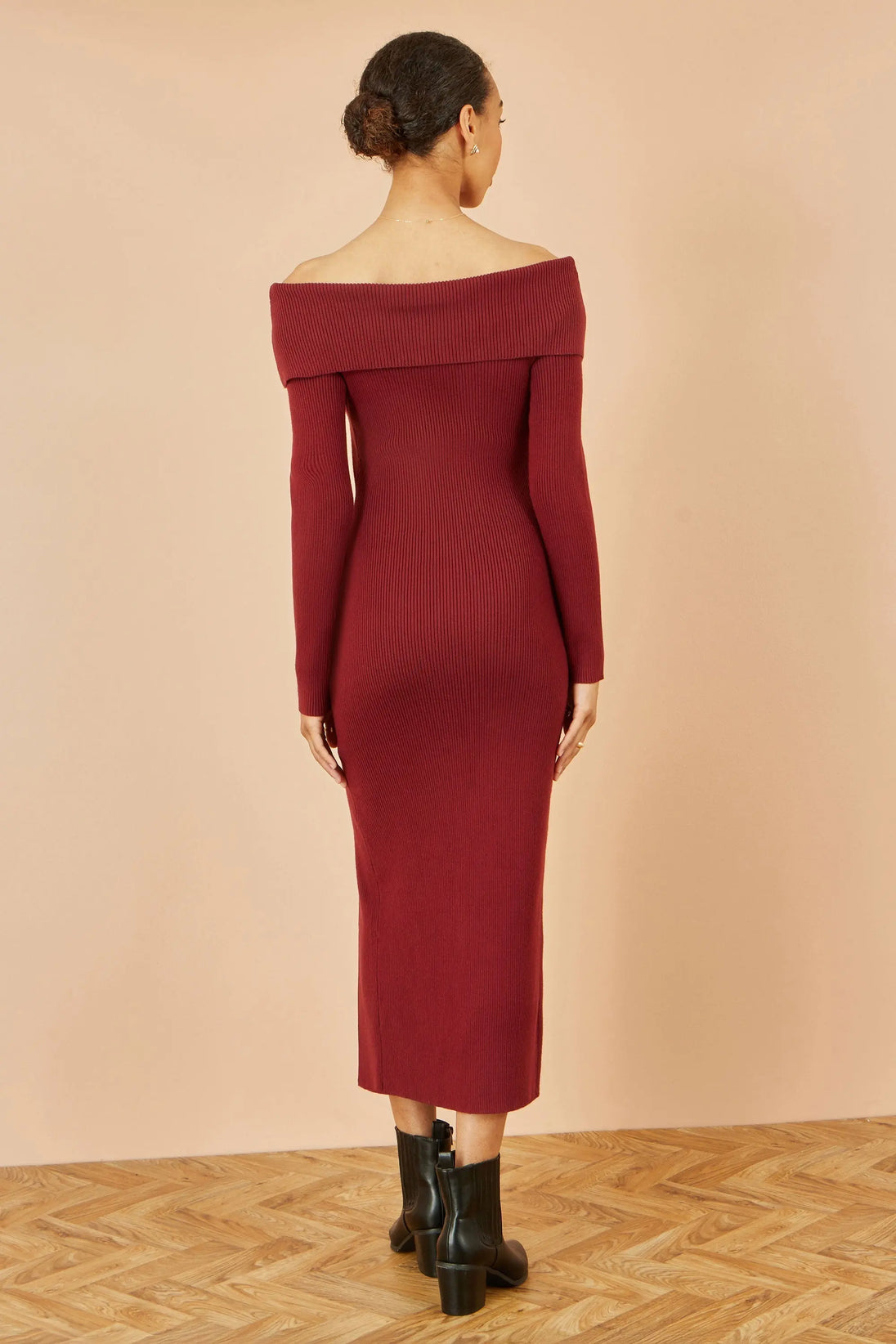 Woman wearing Yumi burgundy Bardot knitted fitted midi dress with long sleeves and split hemline