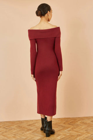 Woman wearing Yumi burgundy Bardot knitted fitted midi dress with long sleeves and split hemline