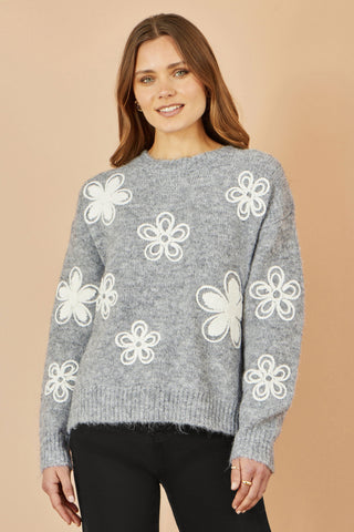 Yumi Grey Relaxed Jumper with white crochet flower details and round neckline on woman