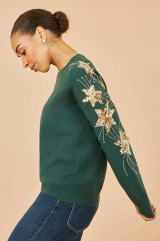 Yumi green relaxed fit jumper with sequin star sleeves on model side view