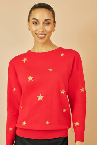 Woman wearing red jumper with gold foil star print and round collar, casual soft knitwear