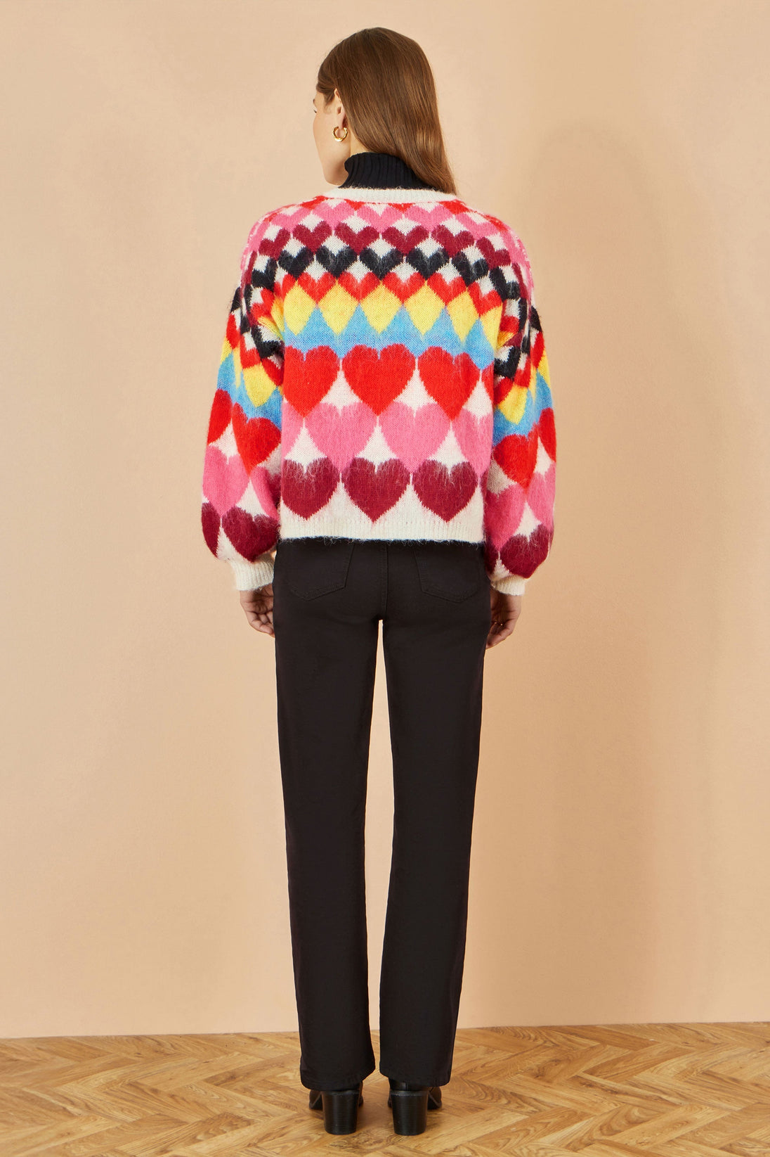 Yumi Multicolour Tie Front Heart Intarsia Cardigan with vibrant heart pattern and tie front fastening on model back view