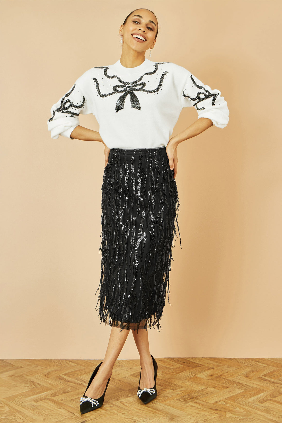 Yumi Black Hanging Sequin fitted midi skirt with shimmering hanging sequins and flattering silhouette.