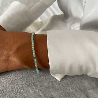 Milos Gemstone amazonite and 22k gold bead bracelet on wrist, adjustable length, luxury pouch included