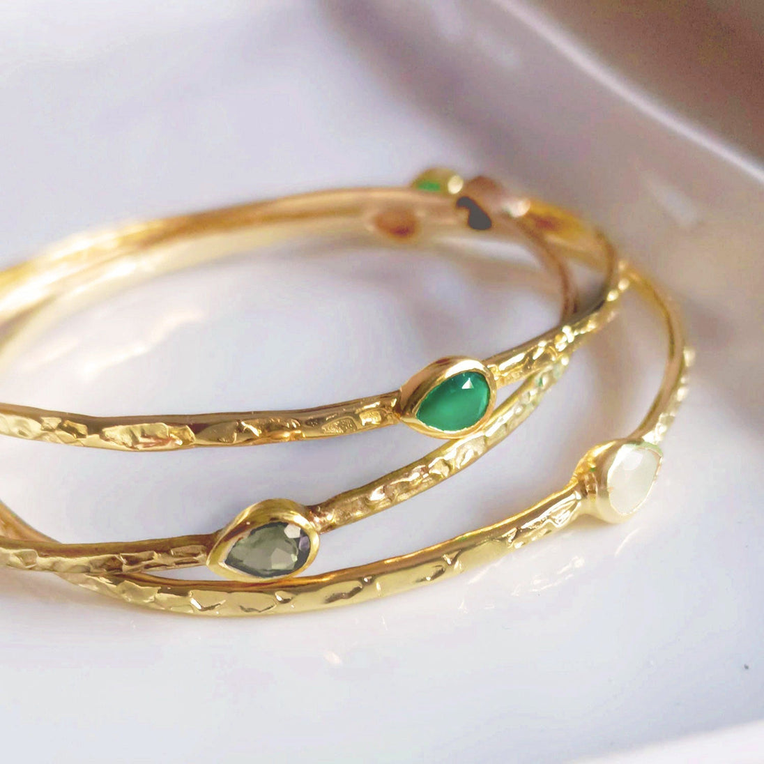 Simi Three Stone Stacking Bangle in 22k gold with three teardrop rainbow moonstones, handcrafted on recycled brass.