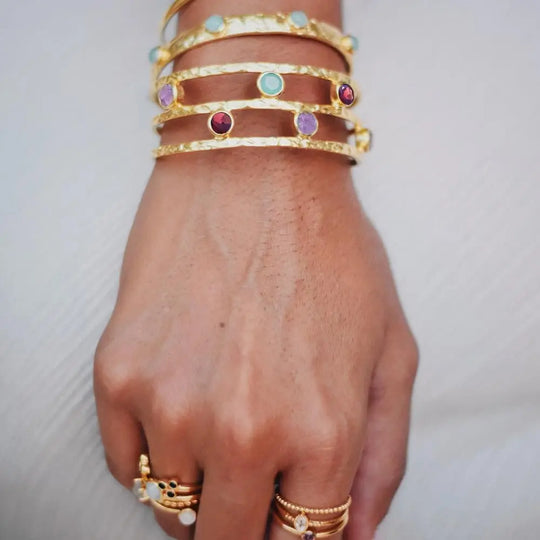 Venus Gemstone Bangle with garnet, peridot, labradorite, and amethyst on wrist, 22k gold brass artisan jewelry