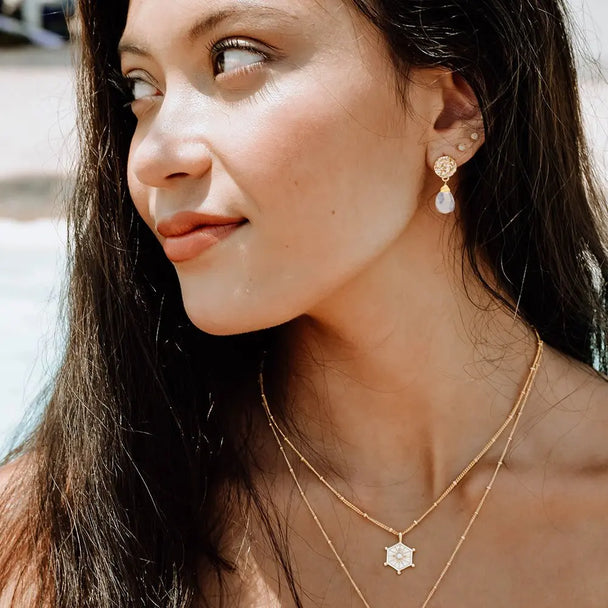 Woman wearing Classic Athena Drop Earrings featuring 22k gold plated coin stud and rainbow moonstone briolette gemstone