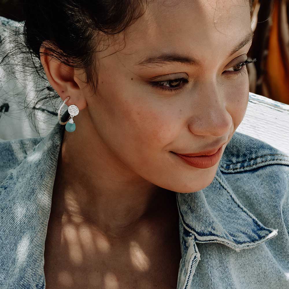 Classic Athena Drop Earrings in sterling silver with aqua Pariba onyx gemstone worn by woman