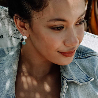 Classic Athena Drop Earrings in sterling silver with aqua Pariba onyx gemstone worn by woman