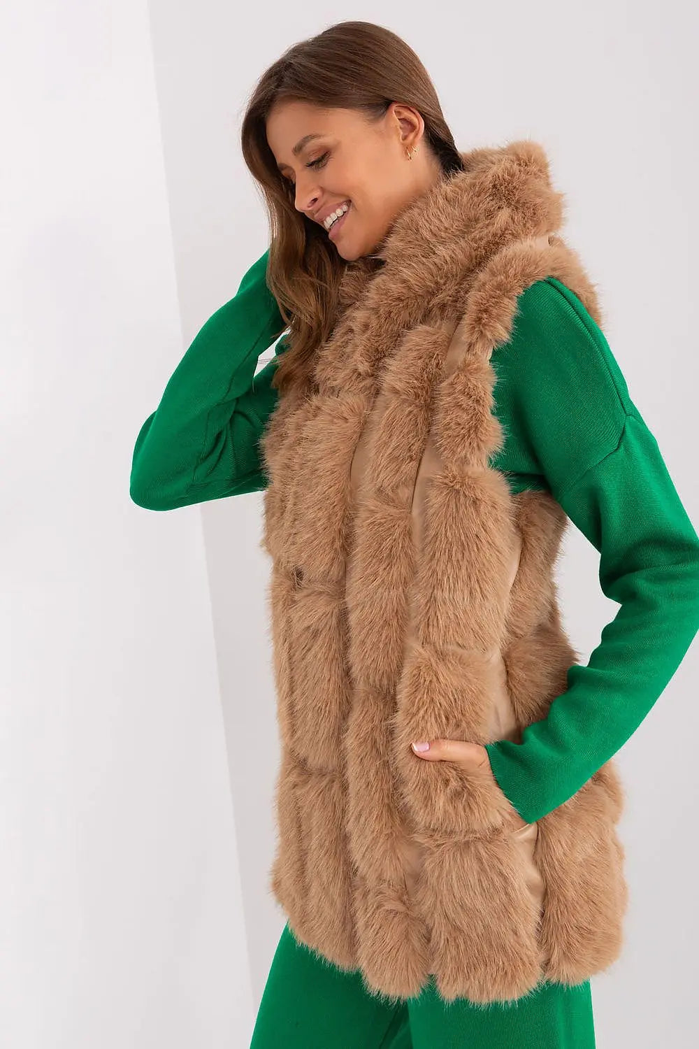 elegant women's hooded faux fur vest in beige worn with green long sleeve top
