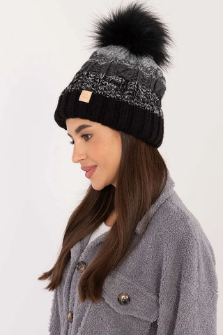 Black and gray two-tone winter beanie with pom-pom and fleece lining on woman
